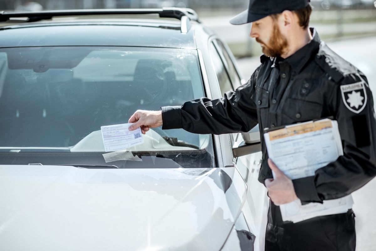guarda de trânsito notificando o condutor por estacionar em local proibido